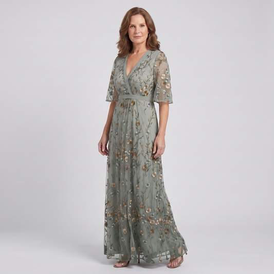 Nora sage green floral maxi dress, three-quarter view showing the defined waist and flowing skirt