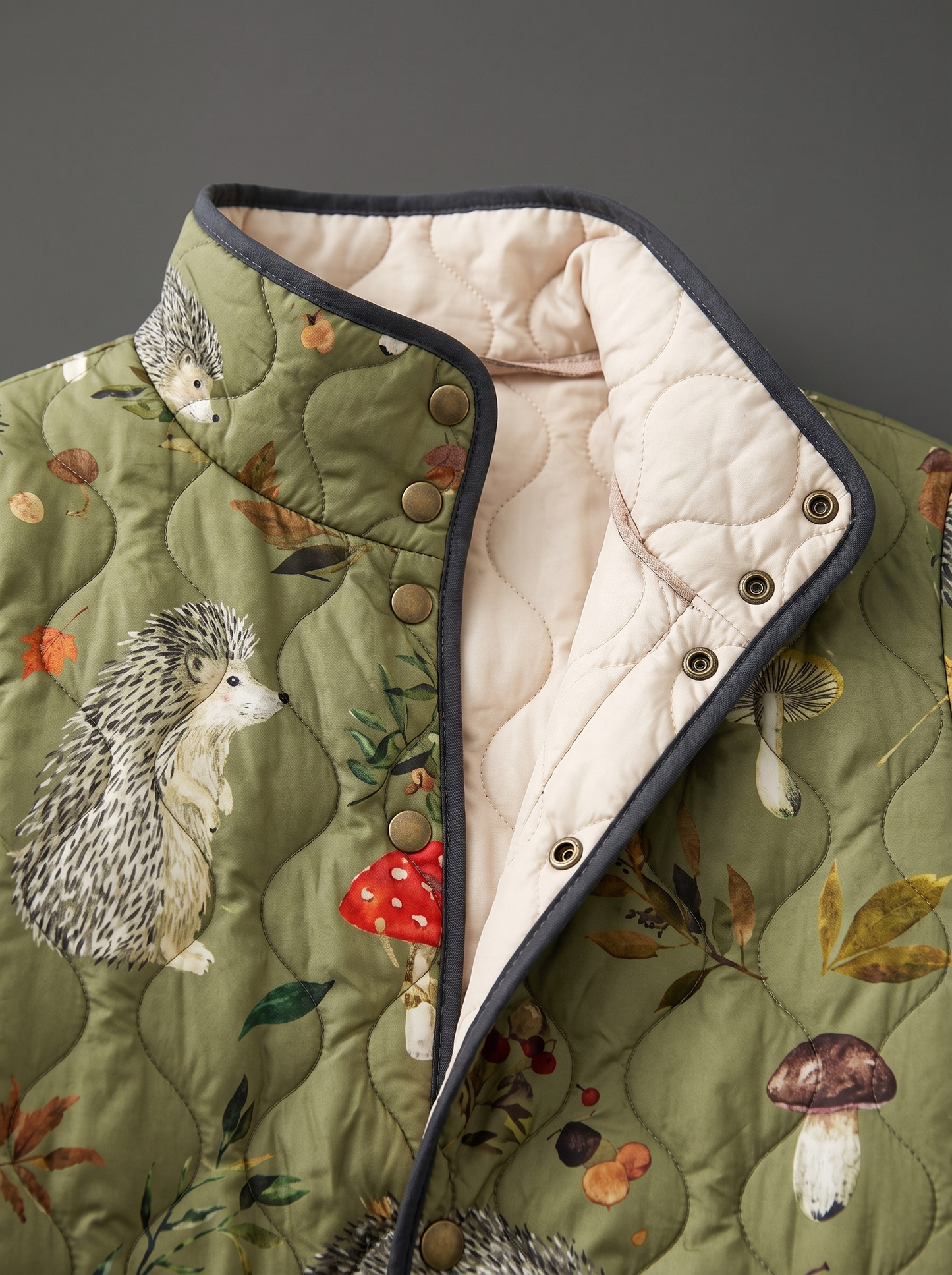 Close view of the stand collar, brass snaps and cream quilted lining on the Fern jacket
