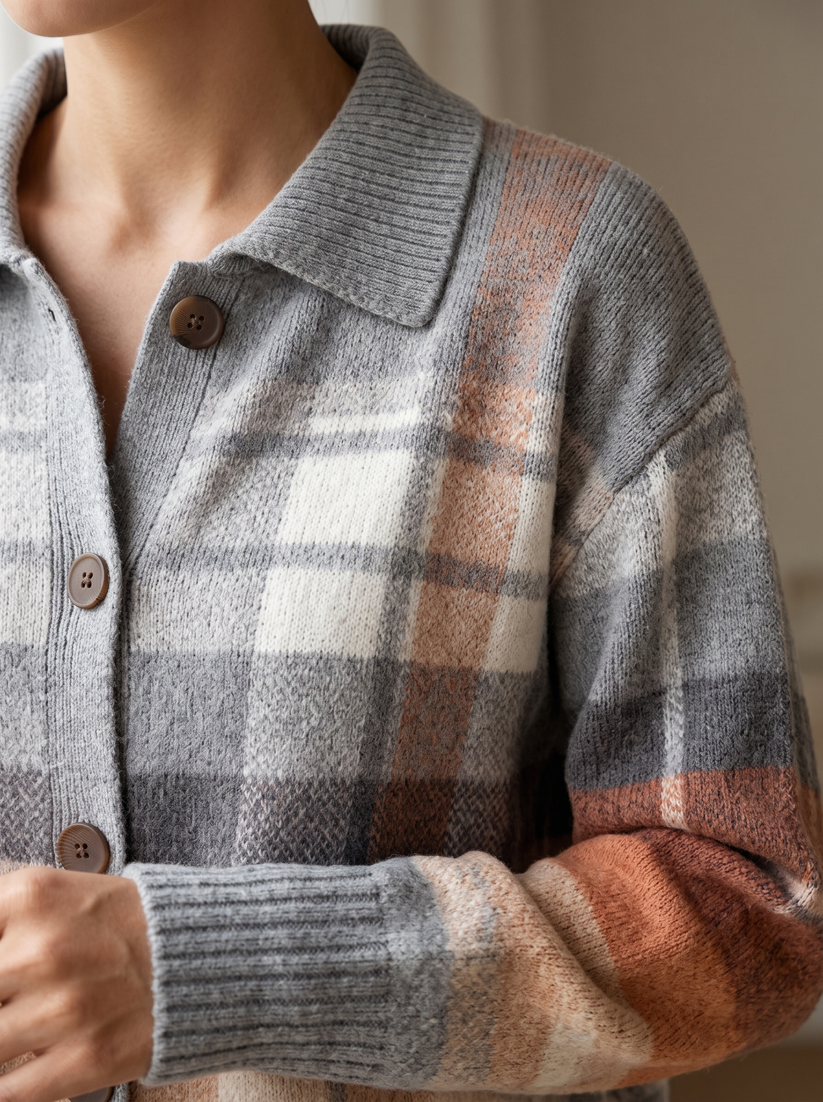 Close view of the collar, brown buttons and ribbed cuff on the Zelda plaid cardigan