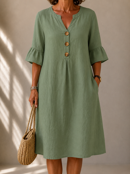 Imogene dress in Sage Green, front view showing the notched neckline and three wood-tone buttons