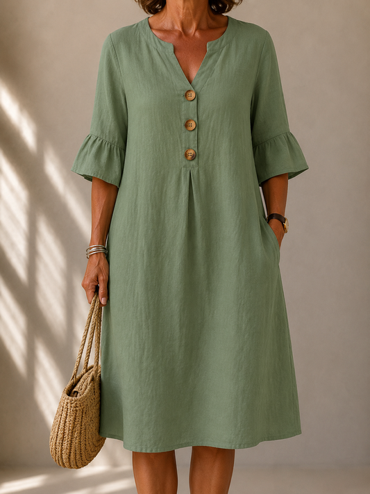 Imogene dress in Sage Green, front view showing the notched neckline and three wood-tone buttons