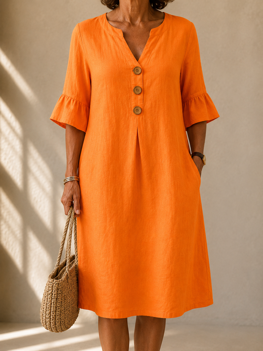 Clarice dress in Orange, front view showing the notched neckline and three wood-tone buttons