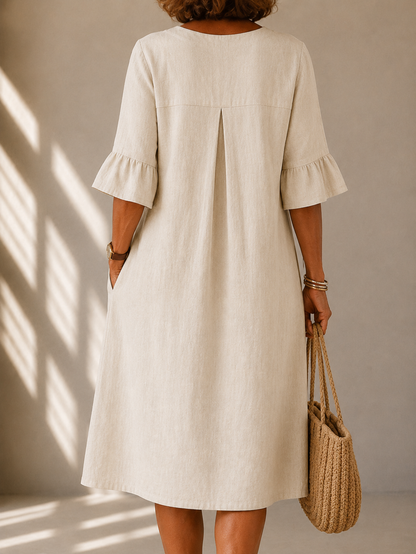 Geraldine dress in Beige, back view showing the box pleat