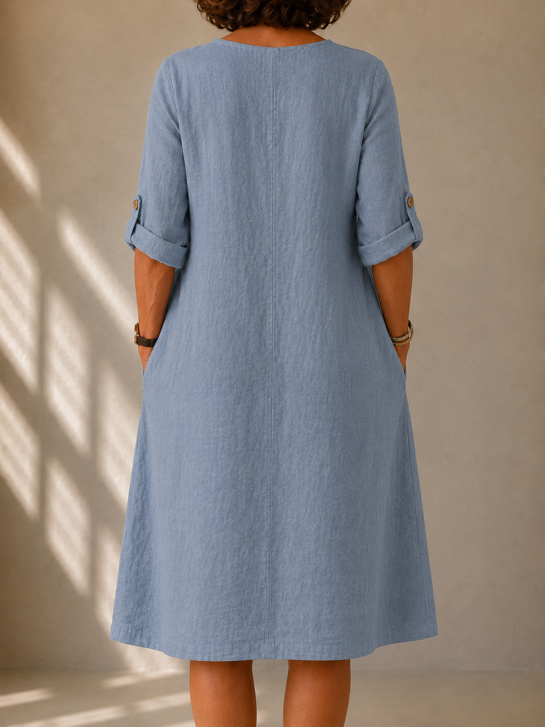 Back view of the Edith dress in Dusty Blue, showing the A-line drape