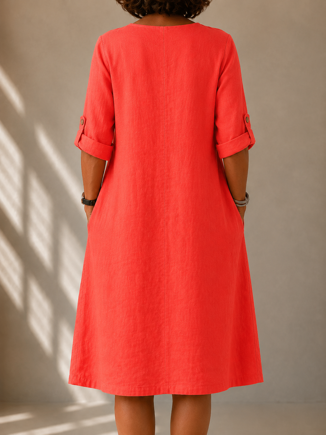 Back view of the Marcella dress in Coral, showing the A-line drape