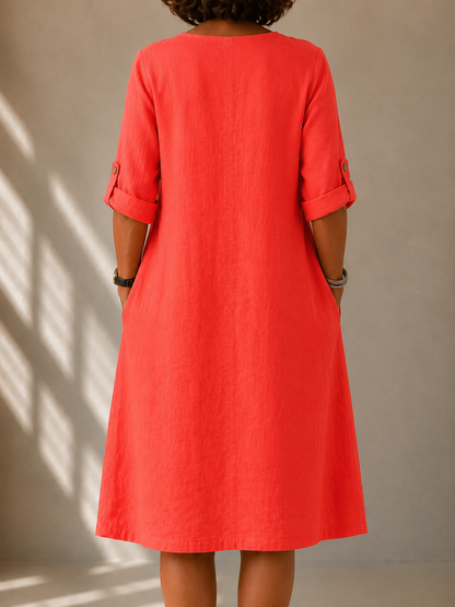 Back view of the Marcella dress in Coral, showing the A-line drape