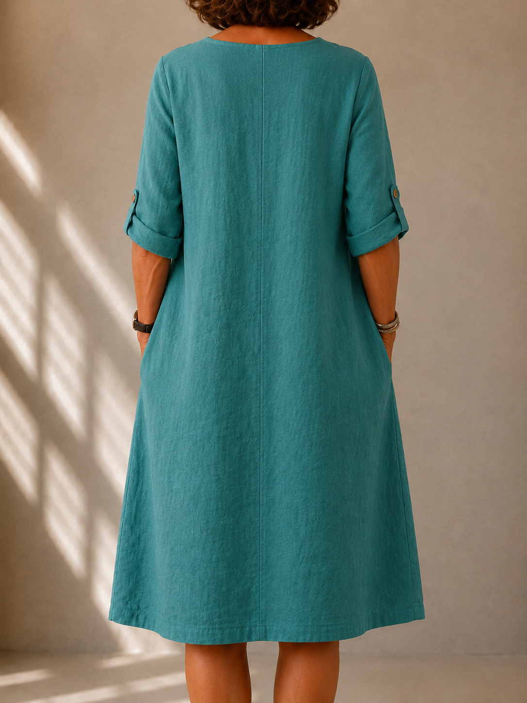 Back view of the Irene dress in Teal, showing the A-line drape