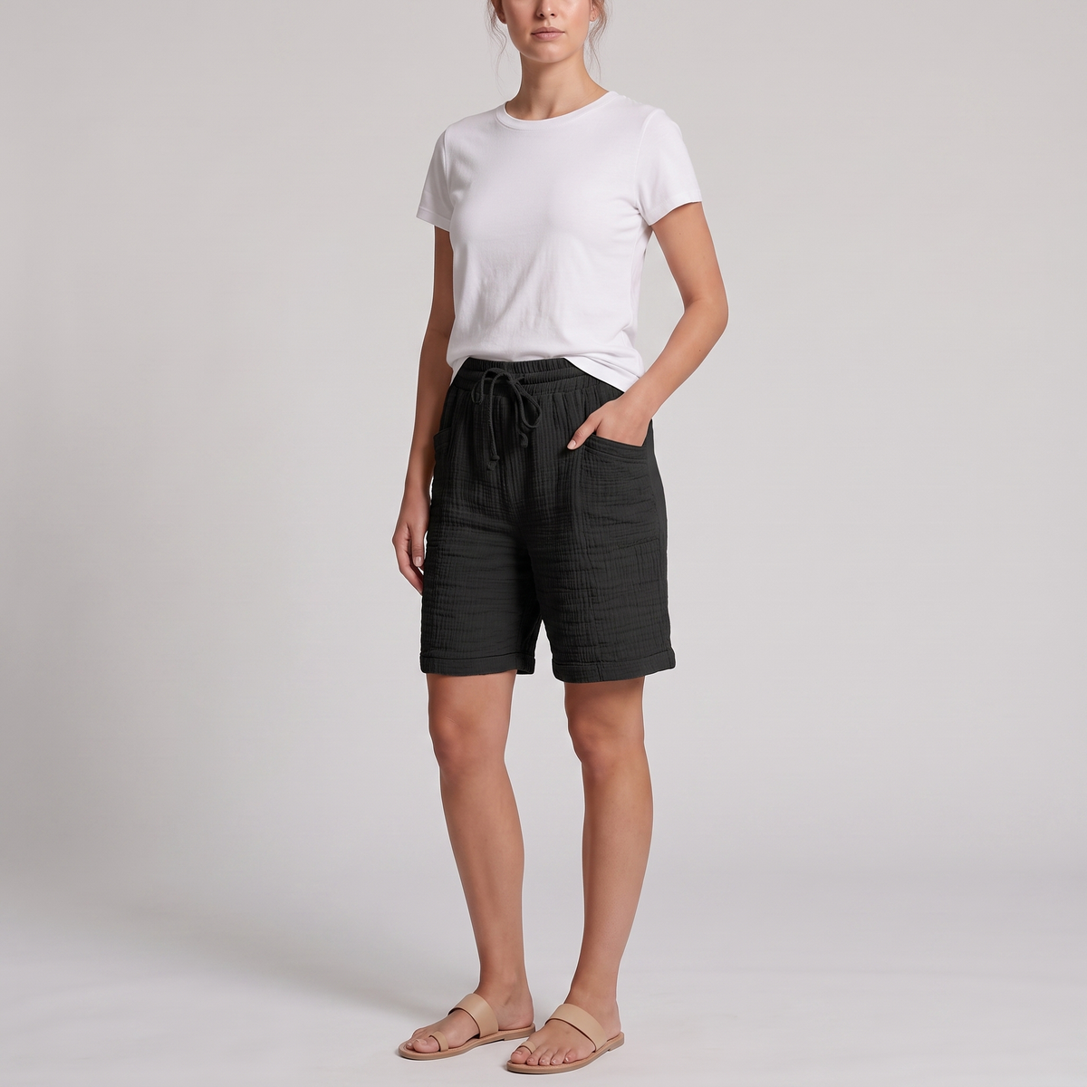 Woman wearing Josie black crinkle cotton bermuda shorts with a white tee