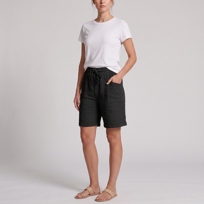 Woman wearing Josie black crinkle cotton bermuda shorts with a white tee