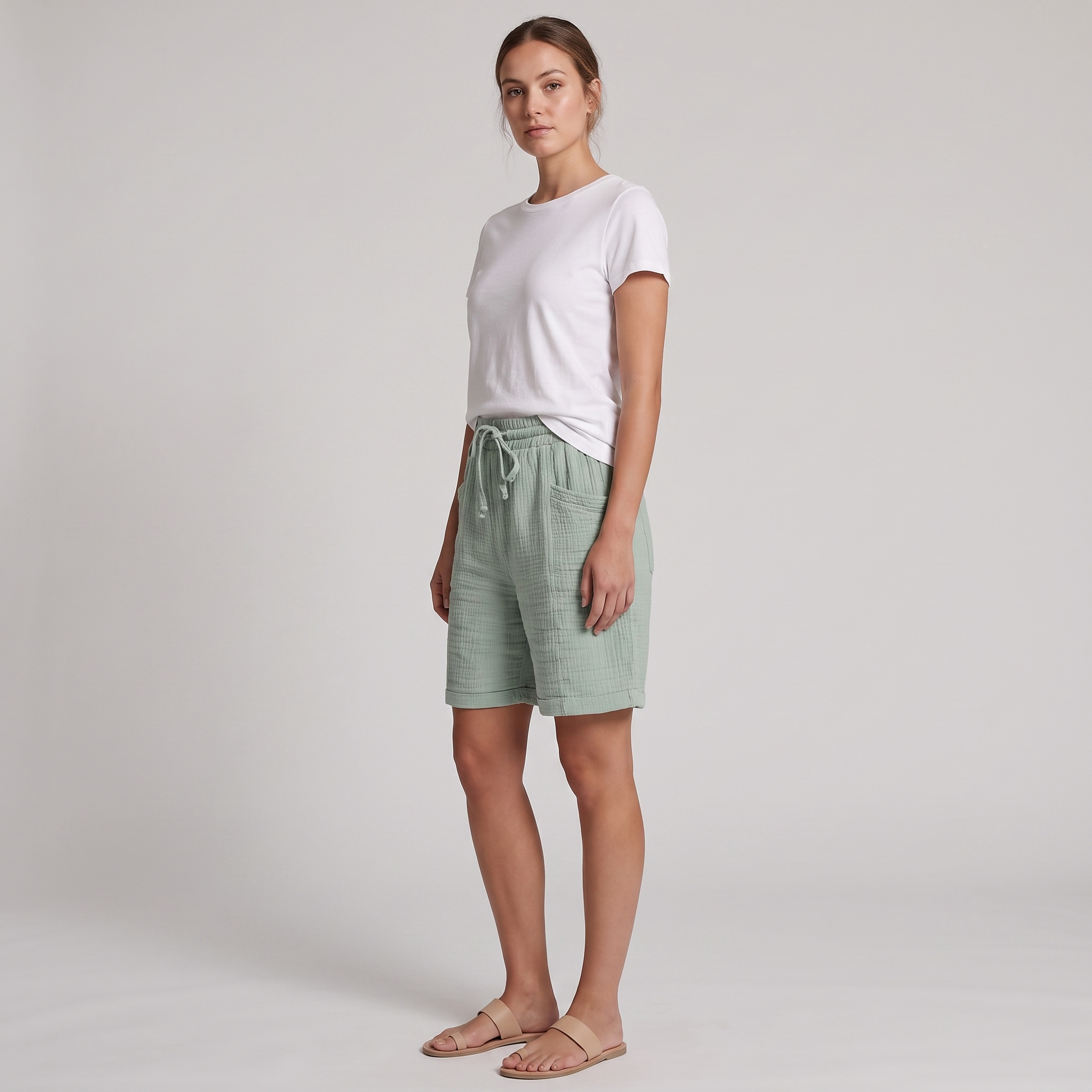 Josie sage green bermuda shorts seen from the side, showing the large patch pocket and rolled cuff