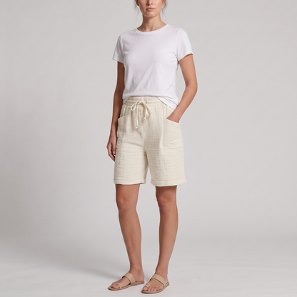 Woman wearing Josie ivory crinkle cotton bermuda shorts with a white tee