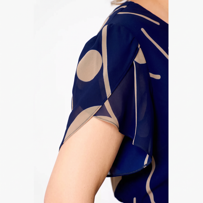 Close-up of the sheer double-layer flutter sleeve and beige dot print on the Marjorie chiffon midi dress