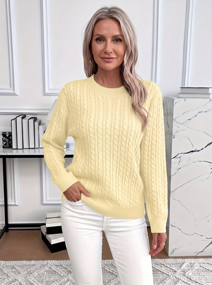 Woman wearing the Evelyn cozy cable knit sweater in pale yellow with white trousers