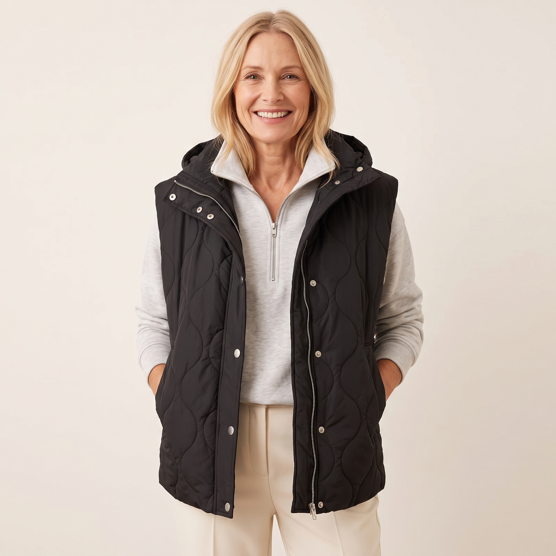 Ramona quilted hooded puffer vest in black, worn open over a grey half-zip