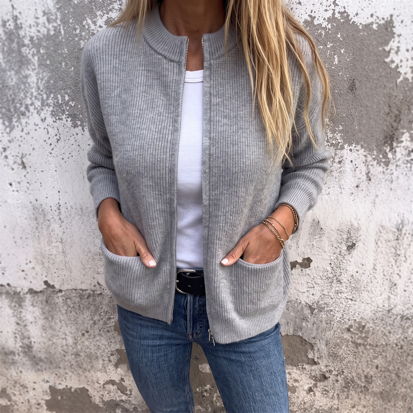 Sylvia zip-front knit cardigan in Heather Gray, worn open over a white tee with hands in the patch pockets
