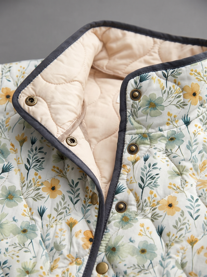 Close view of the stand collar, brass snaps and cream quilted lining on the Flora jacket