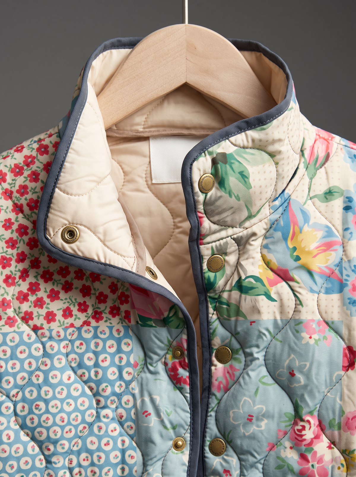 Close view of the stand collar, brass snaps and cream quilted lining on the Emmeline jacket