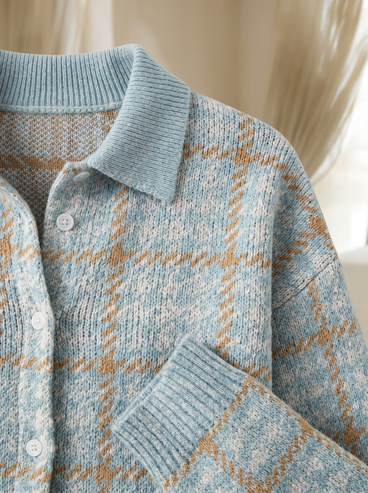 Close view of the collar, buttons and ribbed cuff on the Nettie plaid cardigan