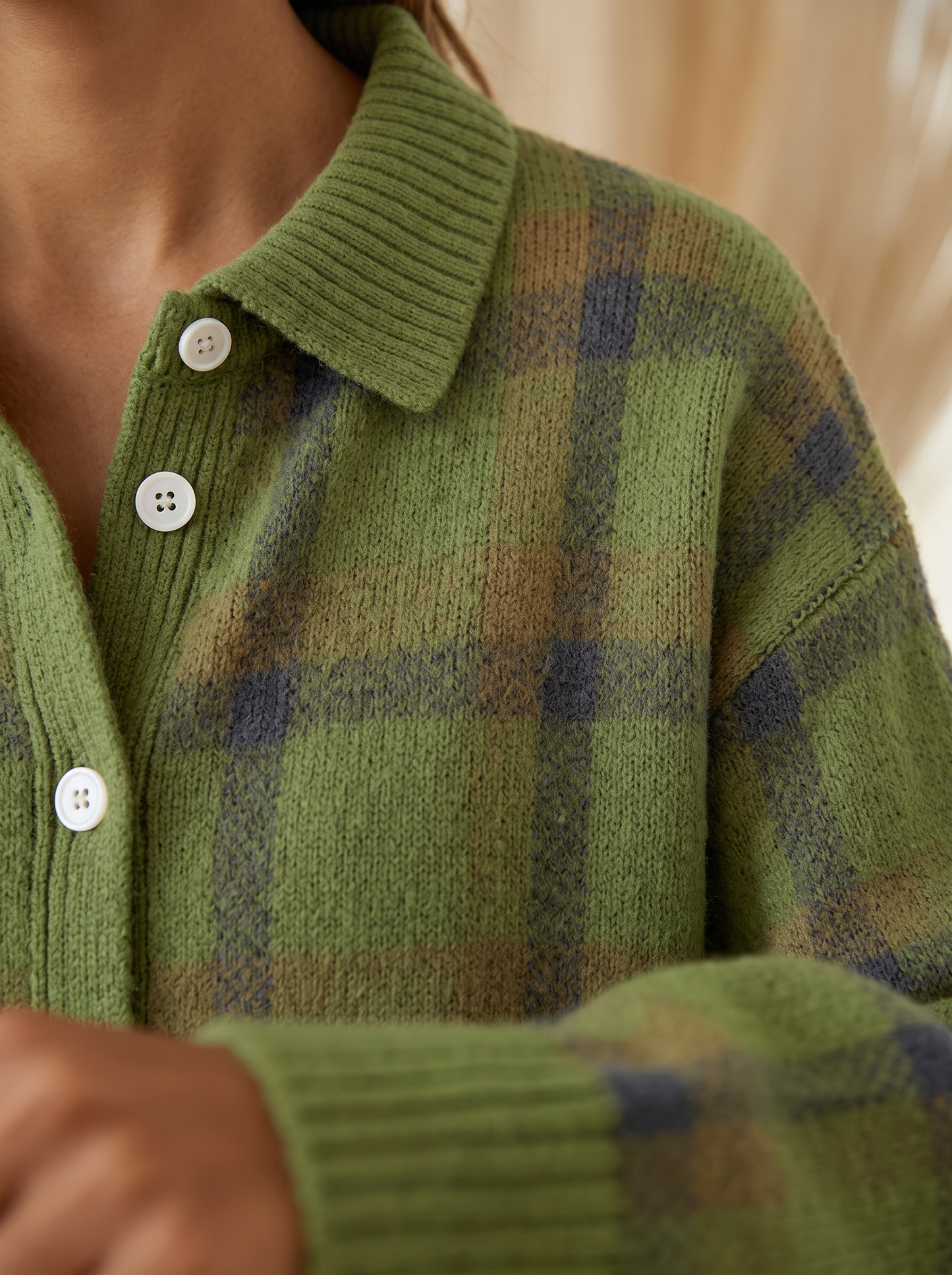 Close view of the collar, buttons and ribbed cuff on the Goldie plaid cardigan
