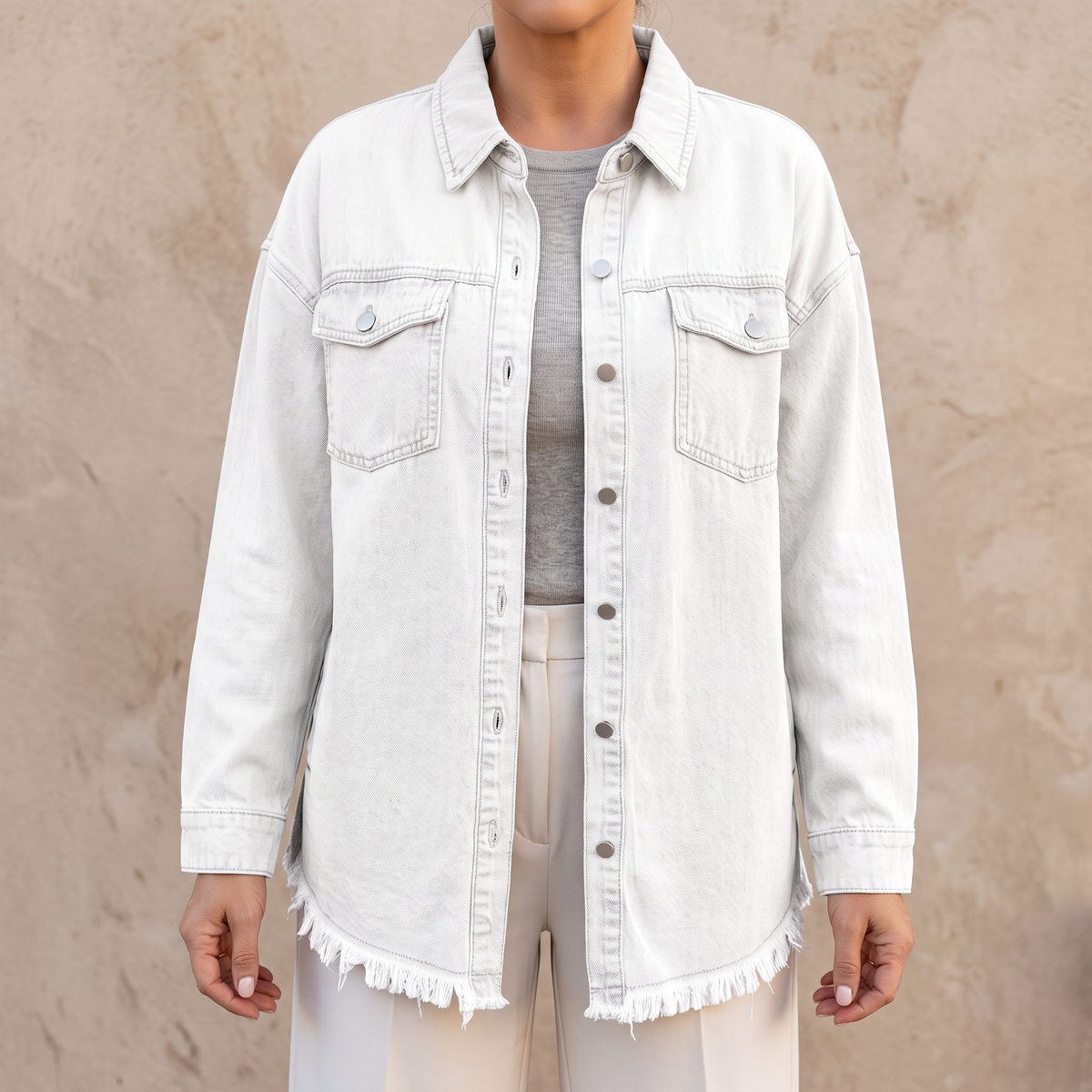 Dottie raw hem denim jacket in white, showing the raw frayed hem and chest patch pockets
