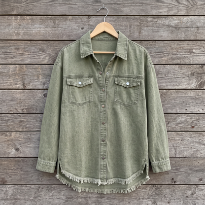 Dottie raw hem denim jacket in olive green, shown on a wooden hanger against a weathered wood plank wall