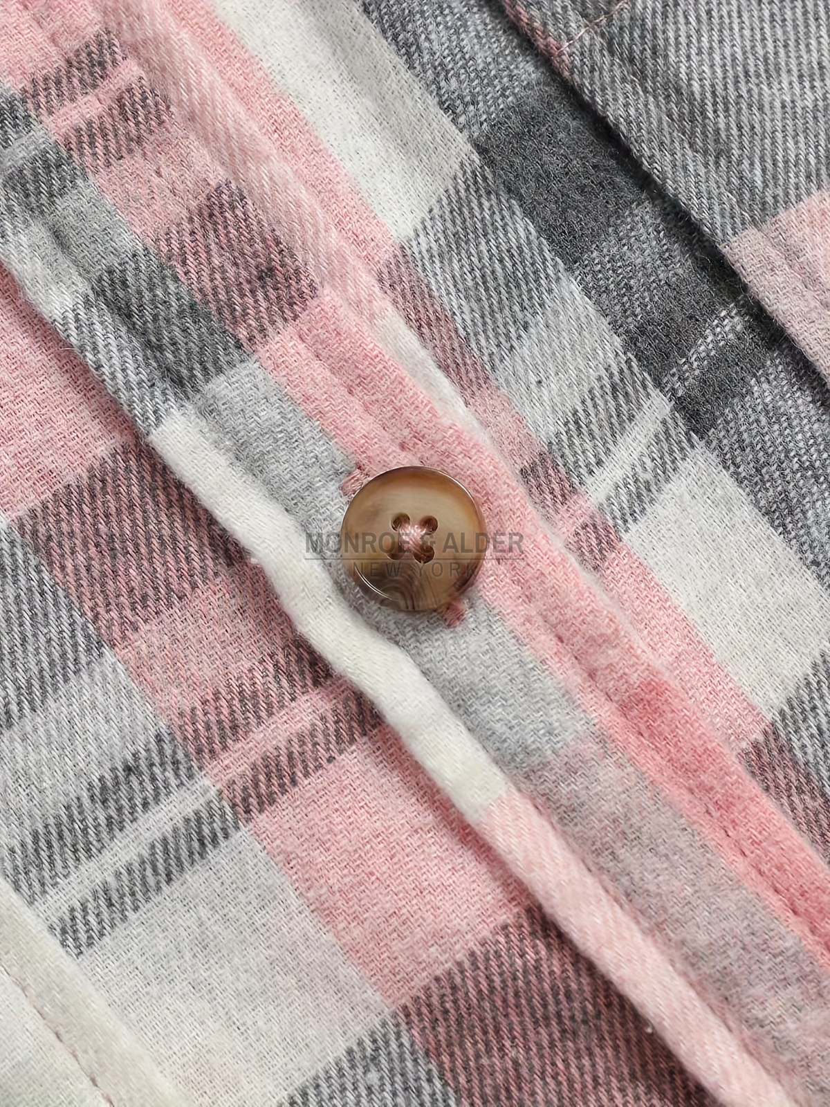 Button detail on the Pink plaid placket
