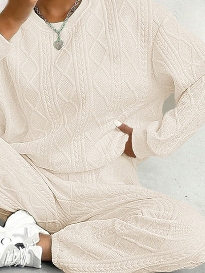 Close view of the textured cable knit on the sweater and pants in cream