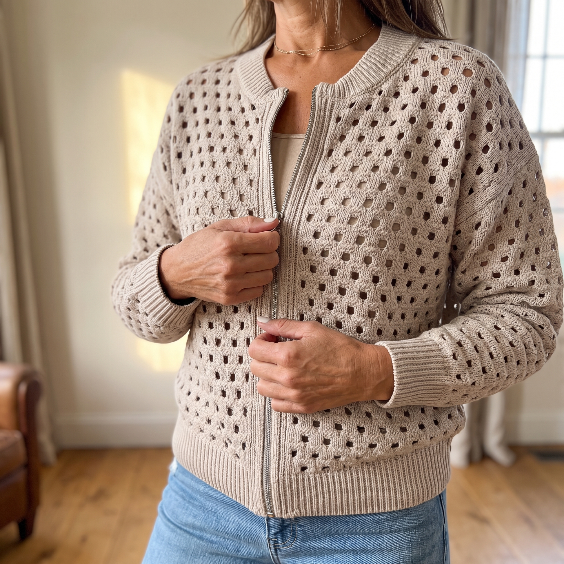 Close view of the open square-cutout knit and the full-length silver zipper
