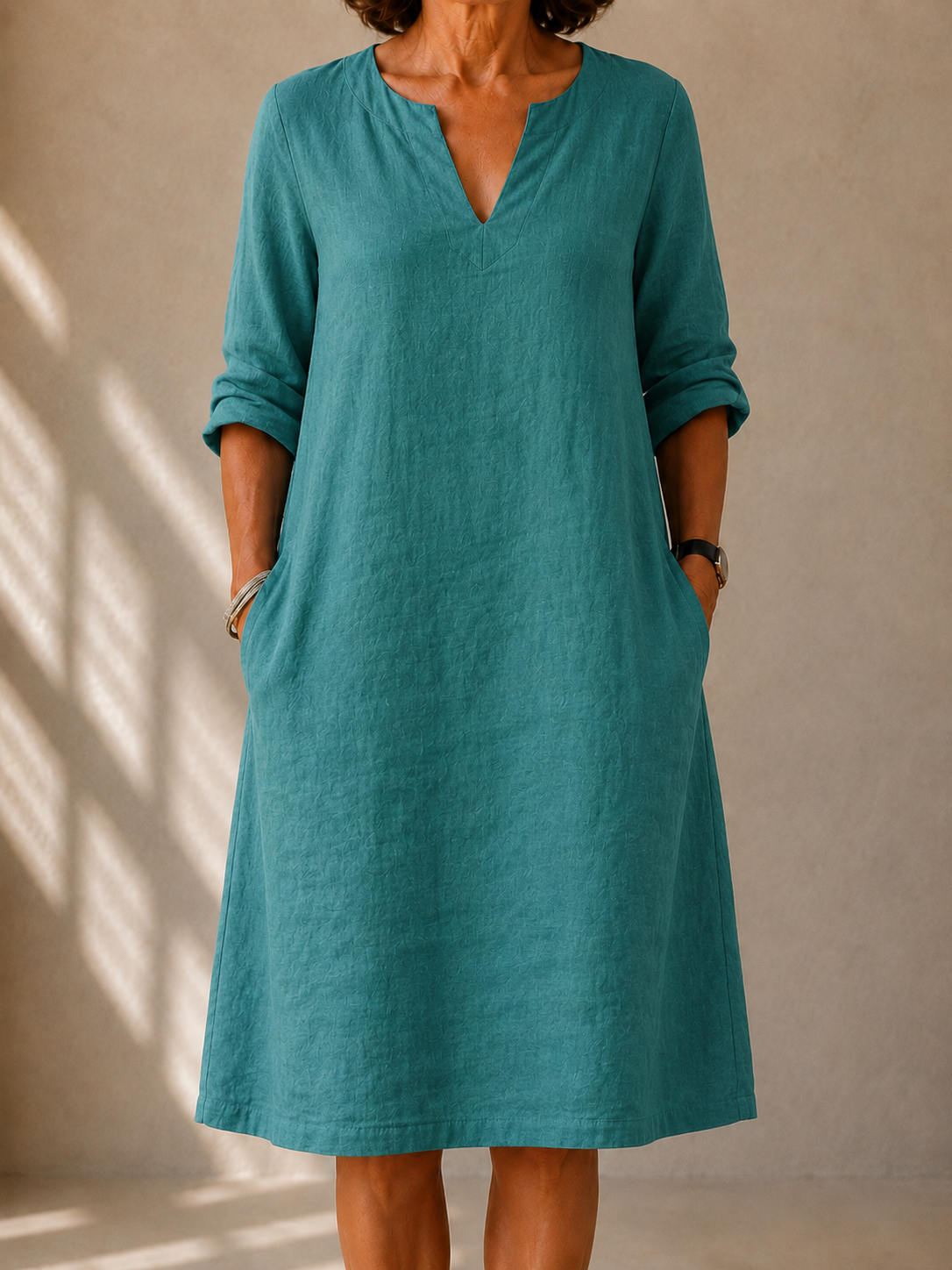 Irene dress in Teal, front view showing the split V-neck and rolled sleeves