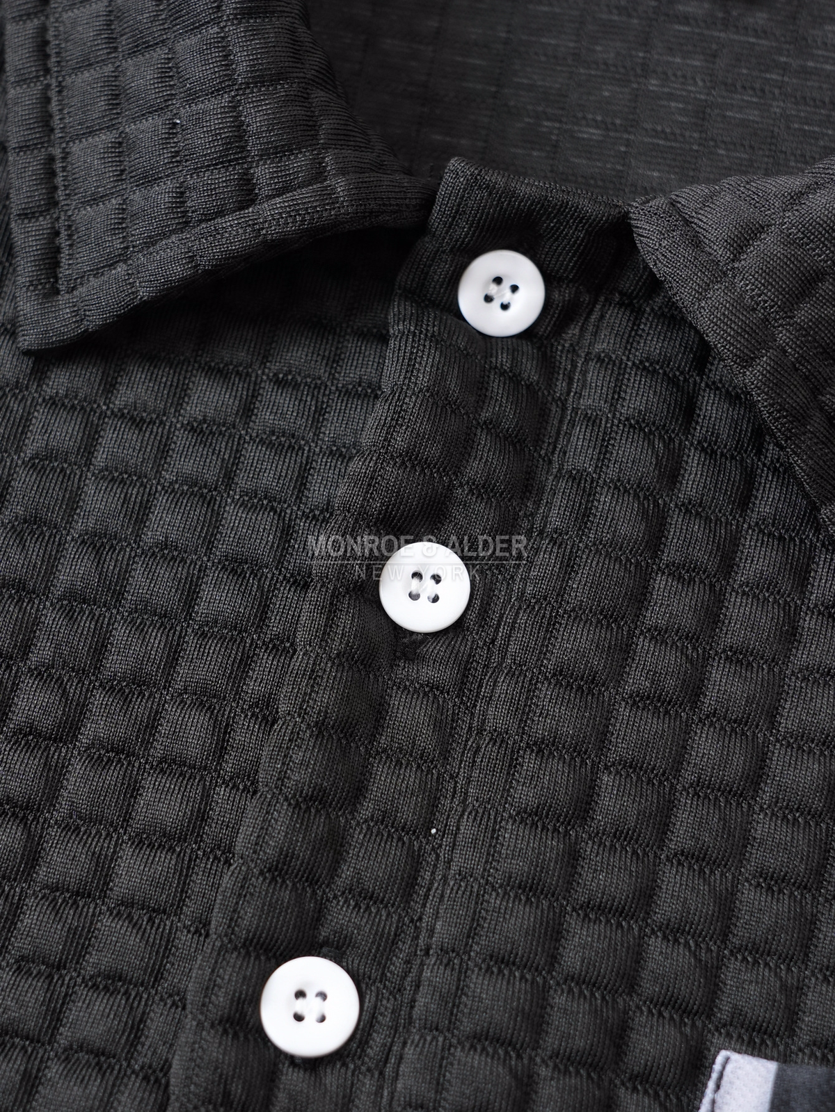 Close view of the button placket and textured grid knit