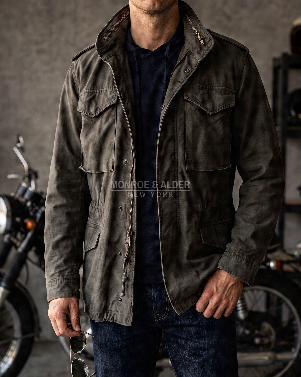 Man wearing the Wyatt field jacket in Dark Olive over a navy tee