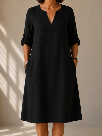 Gloria dress in Black, front view showing the V-notch neckline and roll-tab sleeves